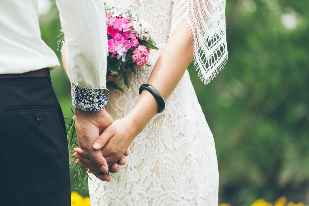 Tangan pasangan pengantin saling menggenggam